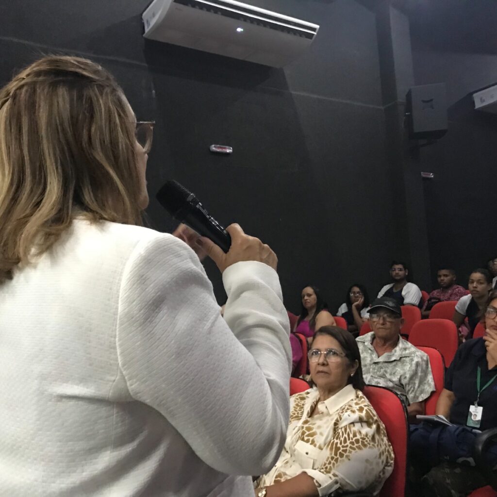 Imagem de um mulher falando para uma plateia.