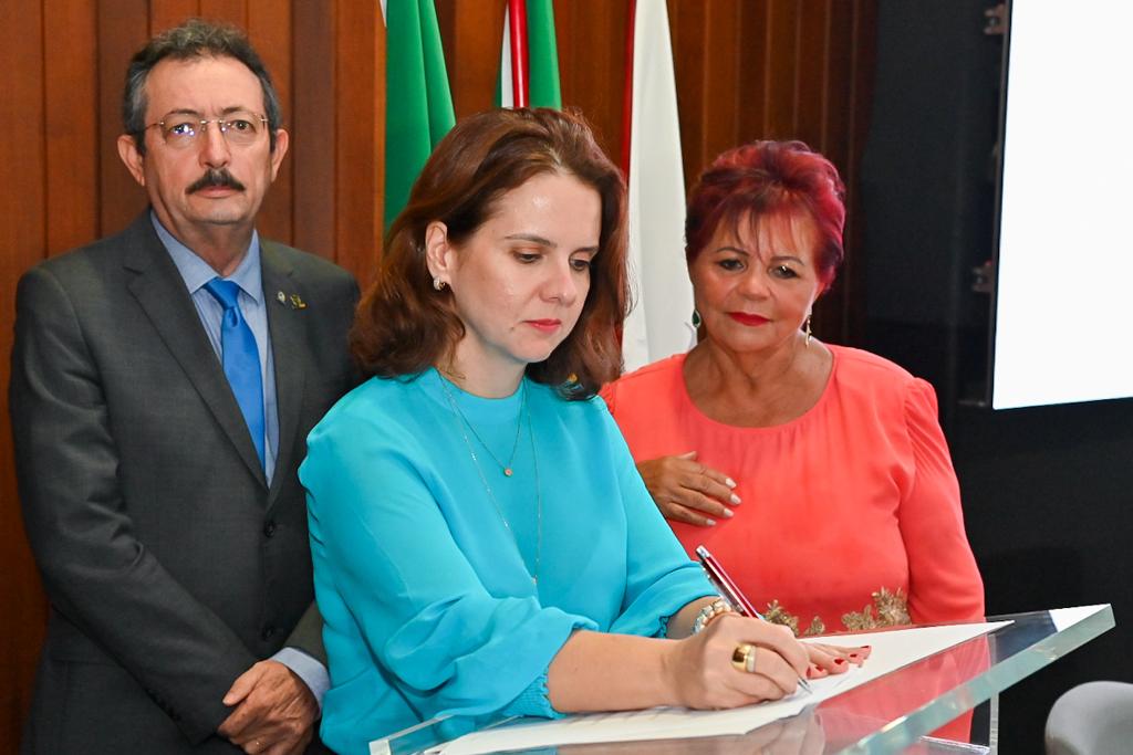 Imagem da procuradora-geral de Justiça, Elaine Cardoso, assinando um documento