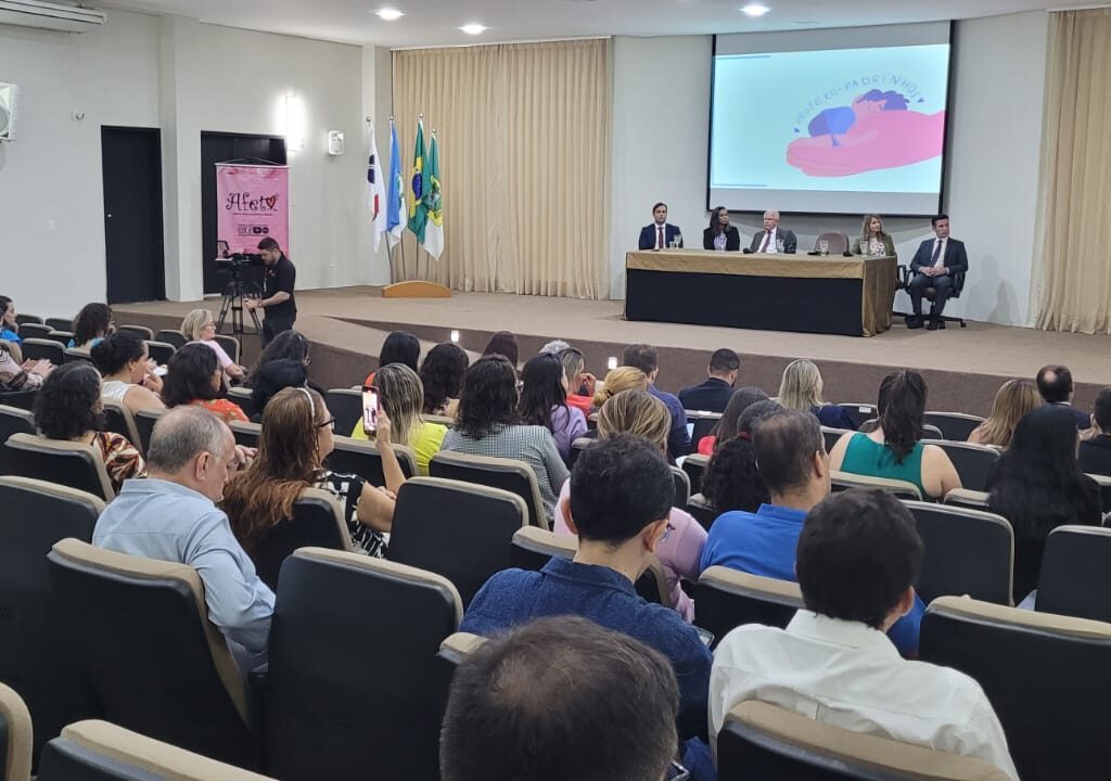 Imagem de um auditório repleto de pessoas, durante uma solenidade.