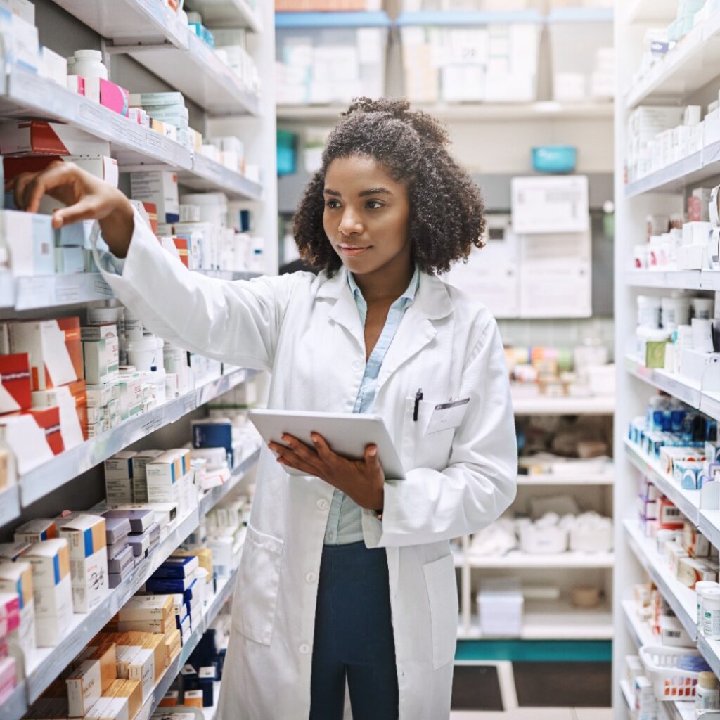 Imagem de uma farmacêutica, mexendo em medicamentos numa prateleira