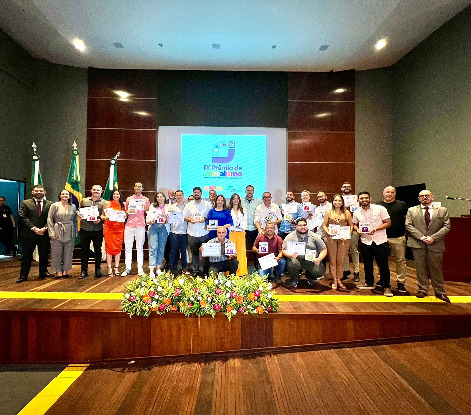 Foto do palco com todos os vencedores premiados.