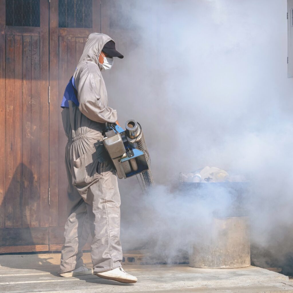 Homem aplicando o fumacê no combate à dengue