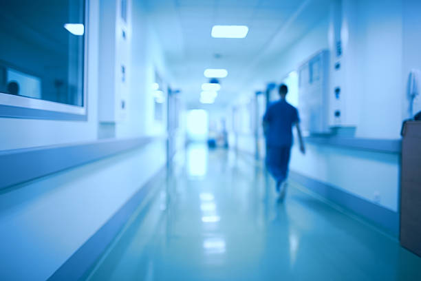 Imagem de coredor de hospital com uma uma pessoa andando