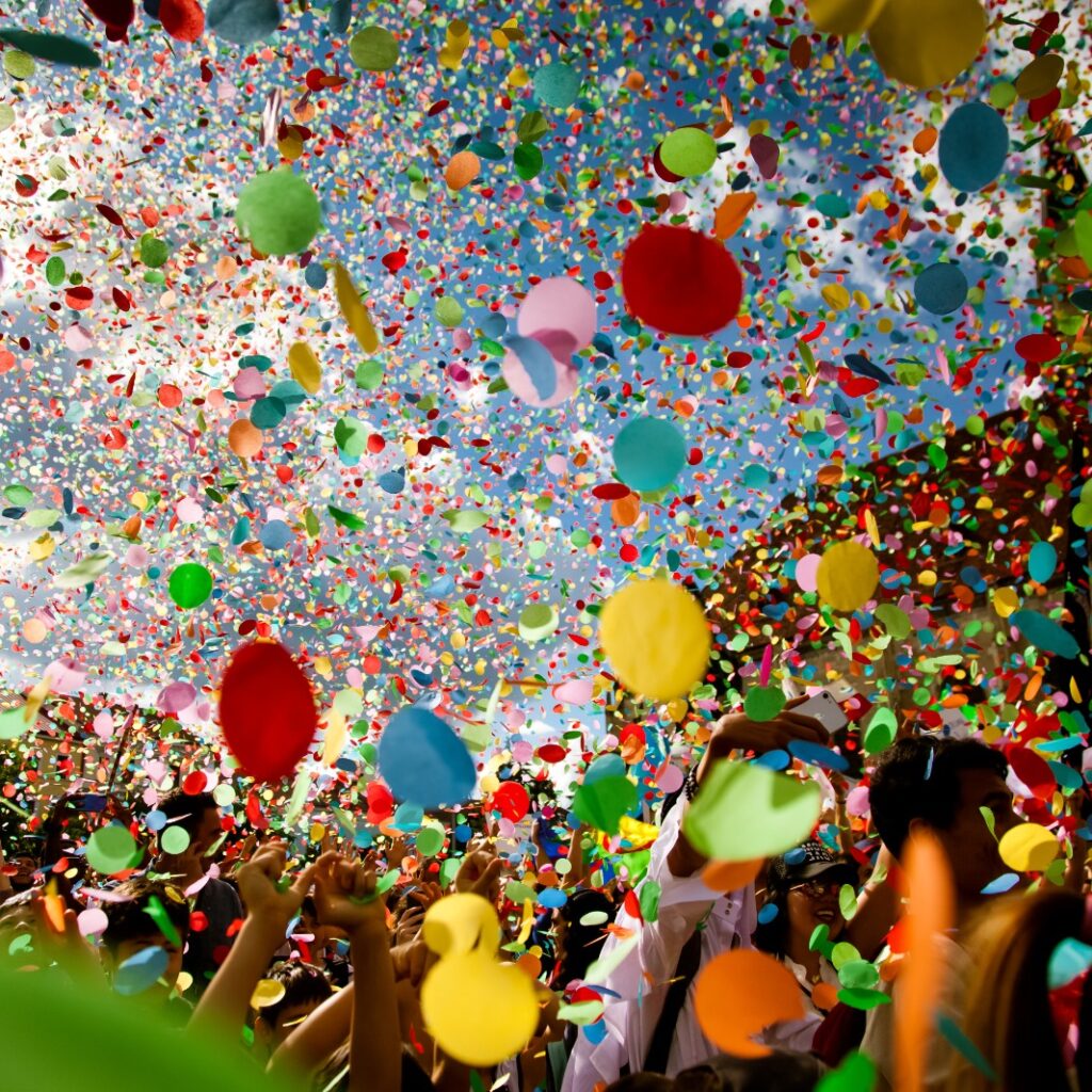Imagem de foliões pulando o carnaval e confetes sendo jogados