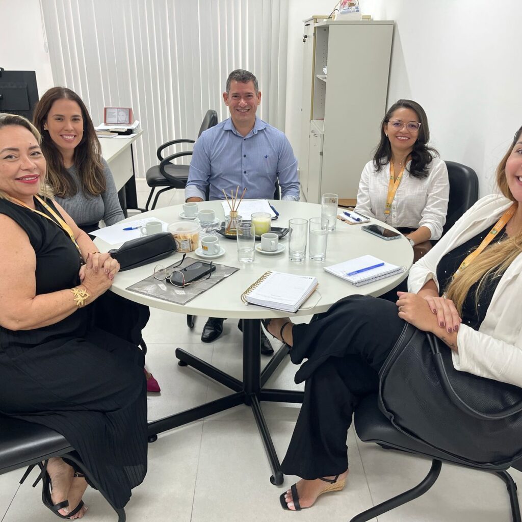 Imagem de pessoas sentadas a mesa durante reunião
