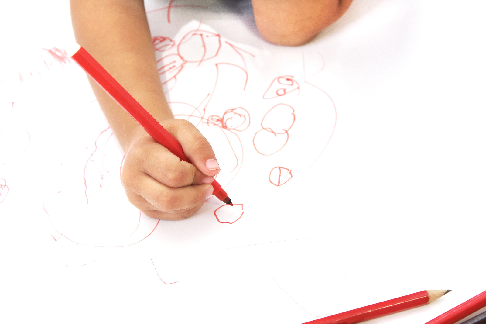 criança desenhando com caneta verm