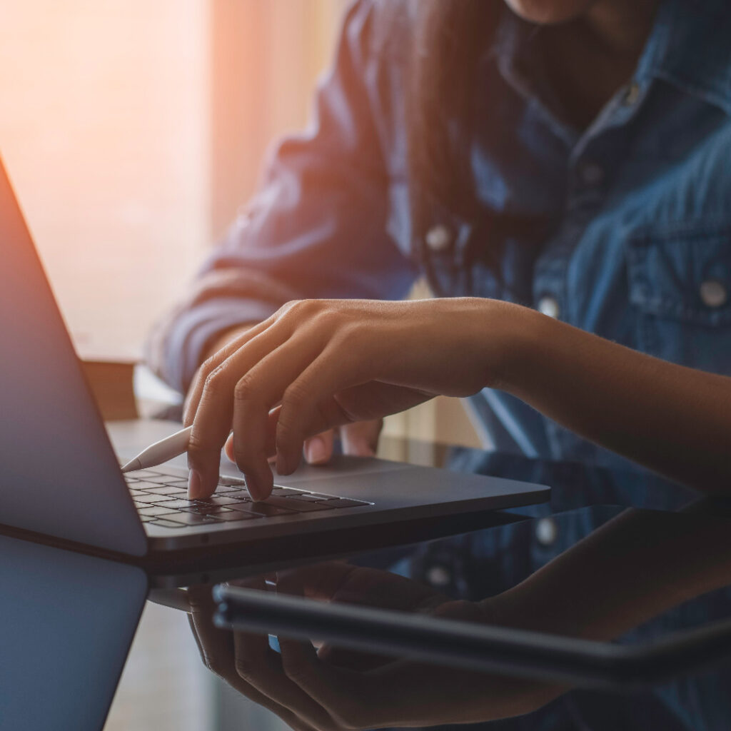 imagem mostranimagem mostrando uma mesa com um computador e uma mulher com a mao no teclado enquanto segura uma canetado uma mesa com um computador e uma mulher com a mao no teclado enquanto segura uma caneta