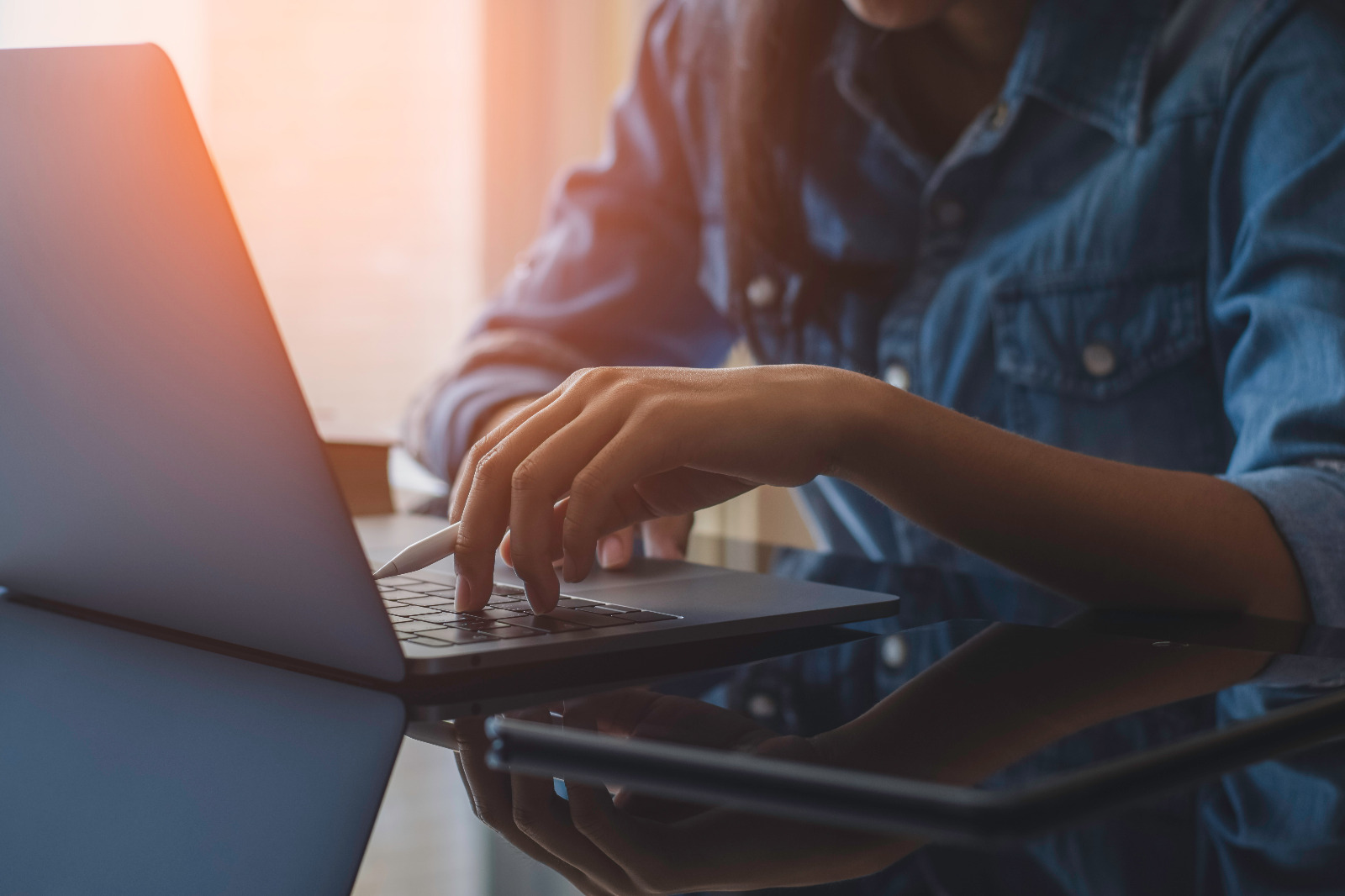 imagem mostranimagem mostrando uma mesa com um computador e uma mulher com a mao no teclado enquanto segura uma canetado uma mesa com um computador e uma mulher com a mao no teclado enquanto segura uma caneta