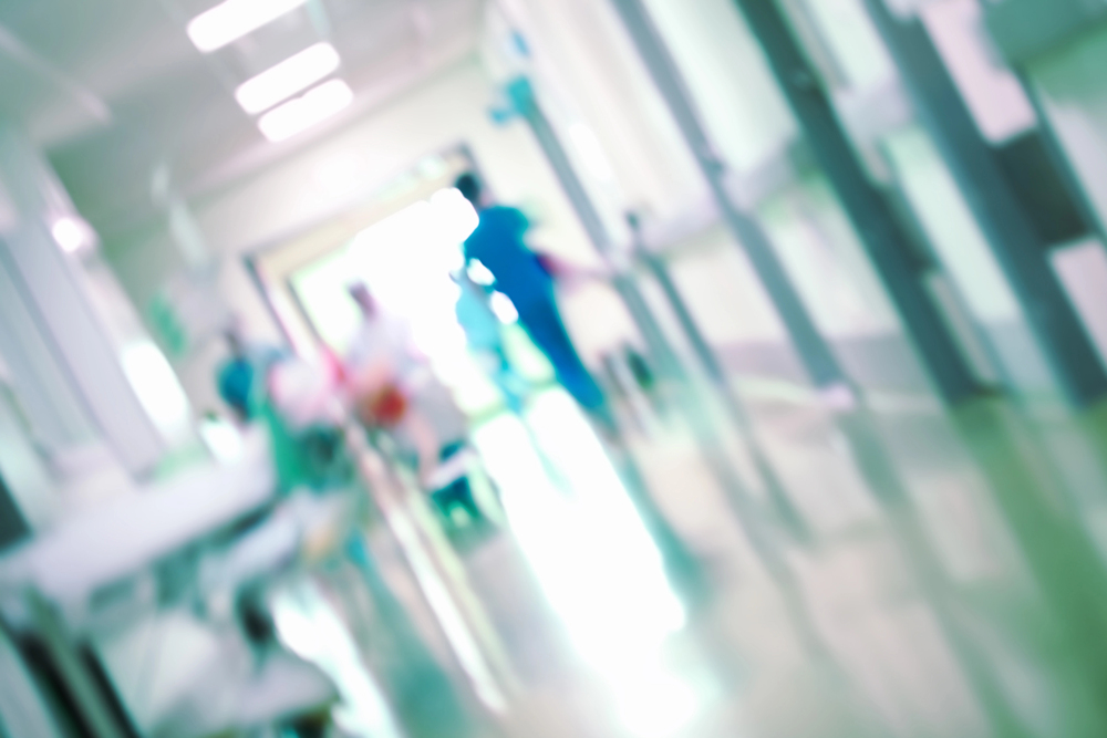 imagem desfocada de corredor de hospital com profissionais andando