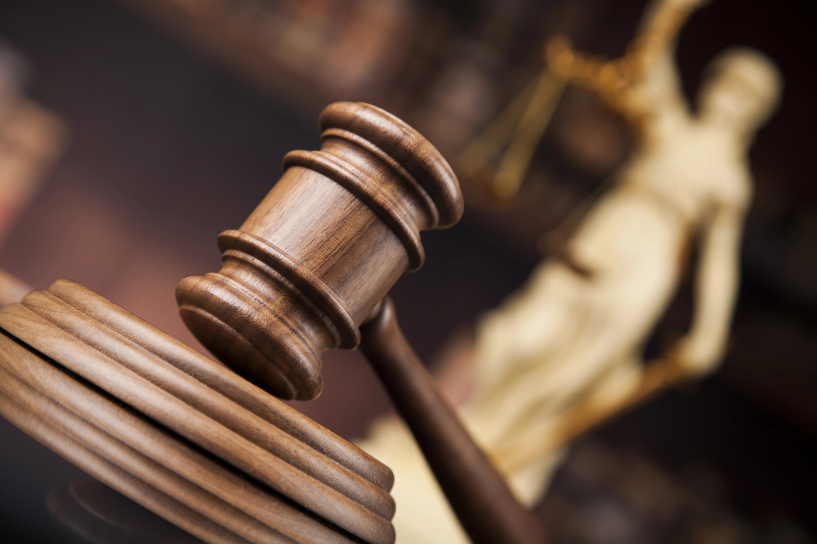 martelo da justiça em plano incial com estatua da justiça ao fundo