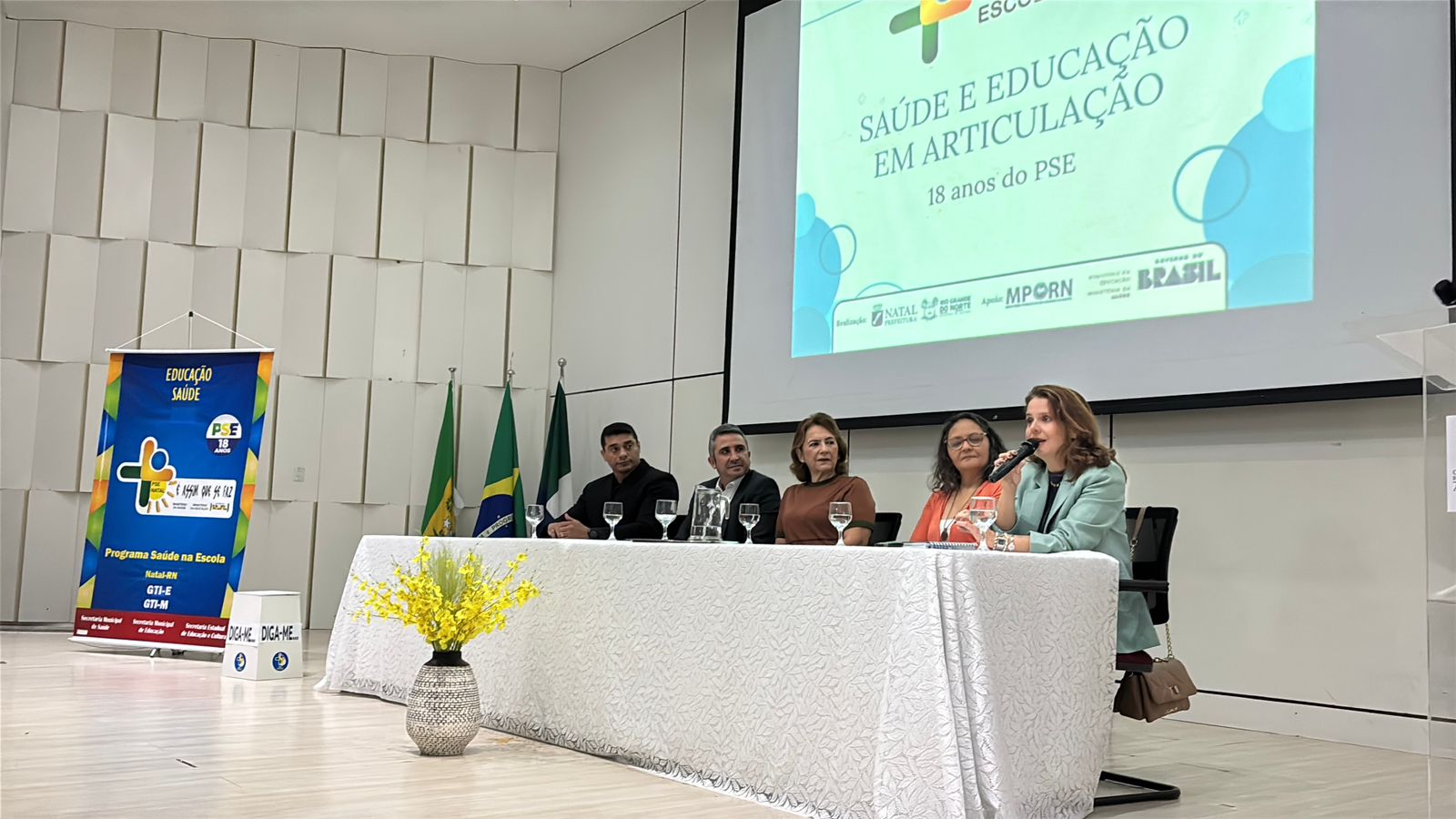 pessoas sentada em uma mesa no palco