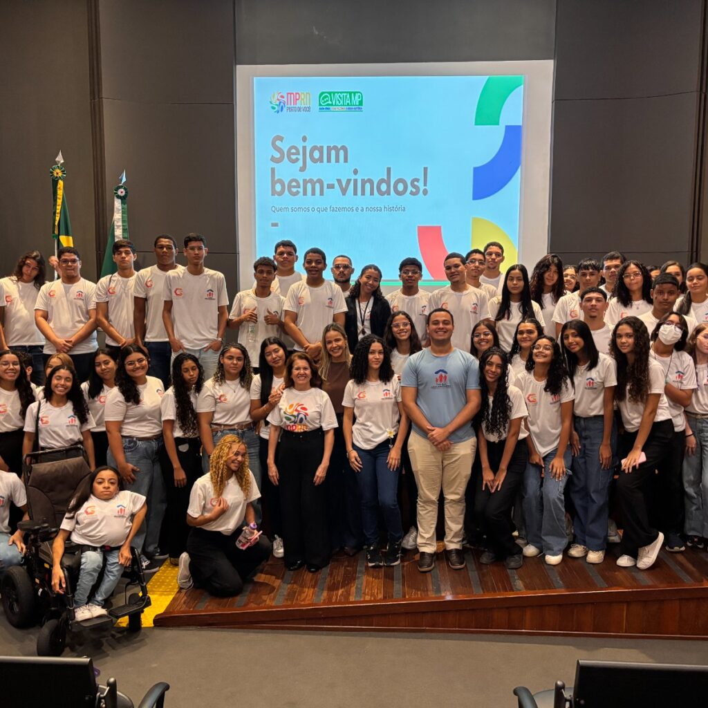 Alunos da Casa do Menor trabalhador em pé no palco do auditorio do mprn