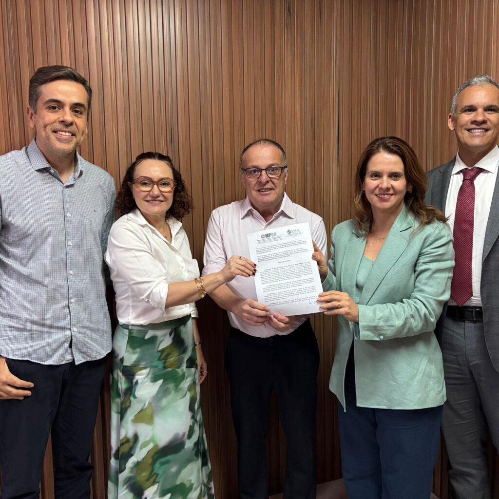 cinco pessoas em pé segurando um papel