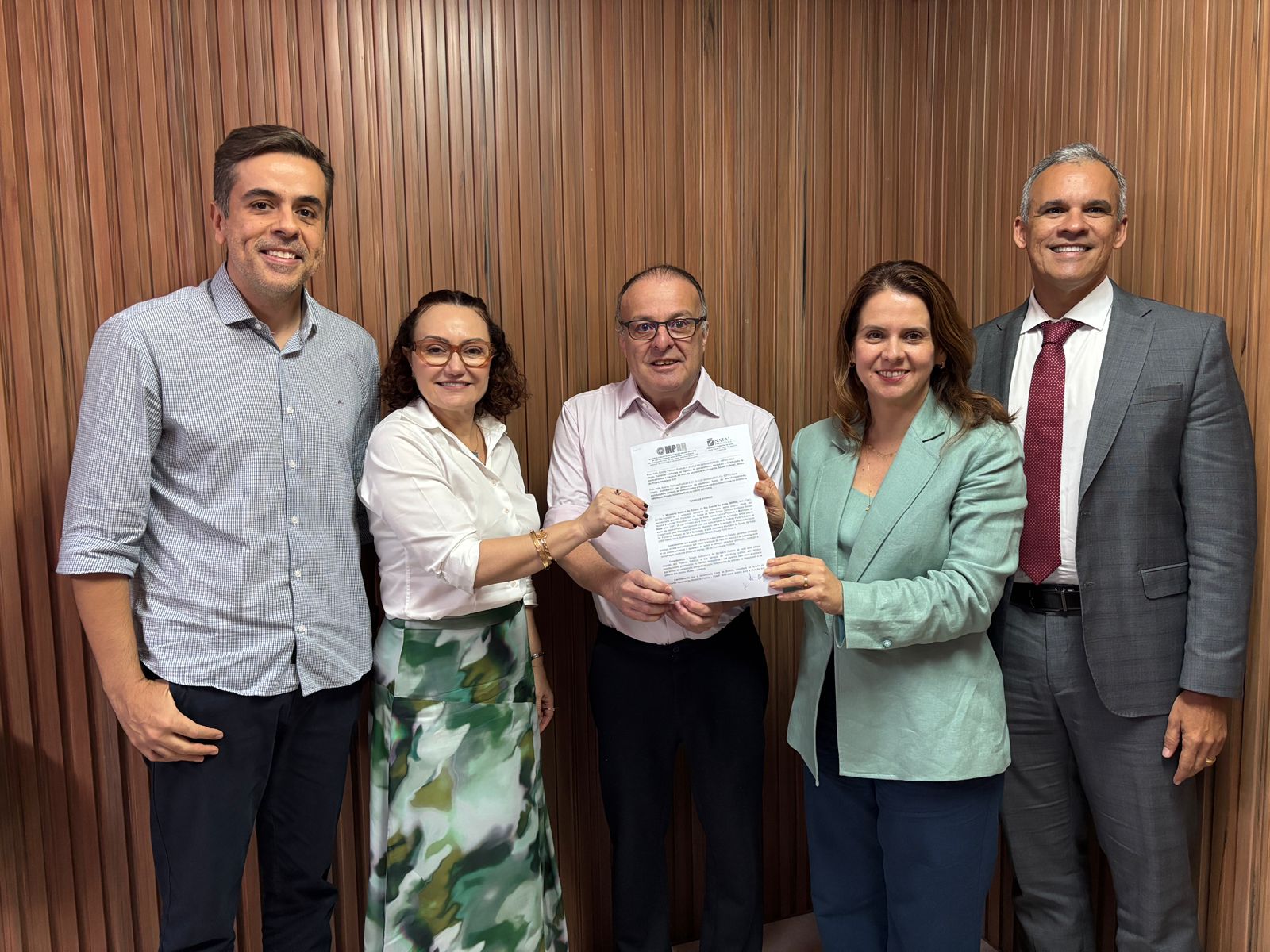 cinco pessoas em pé segurando um papel