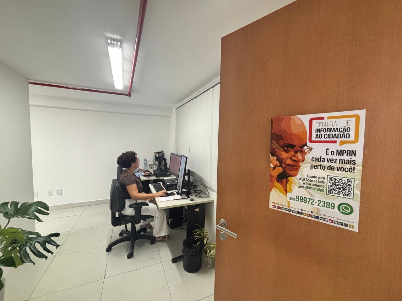 sala com pessoas trabalhando sentadas em um computador