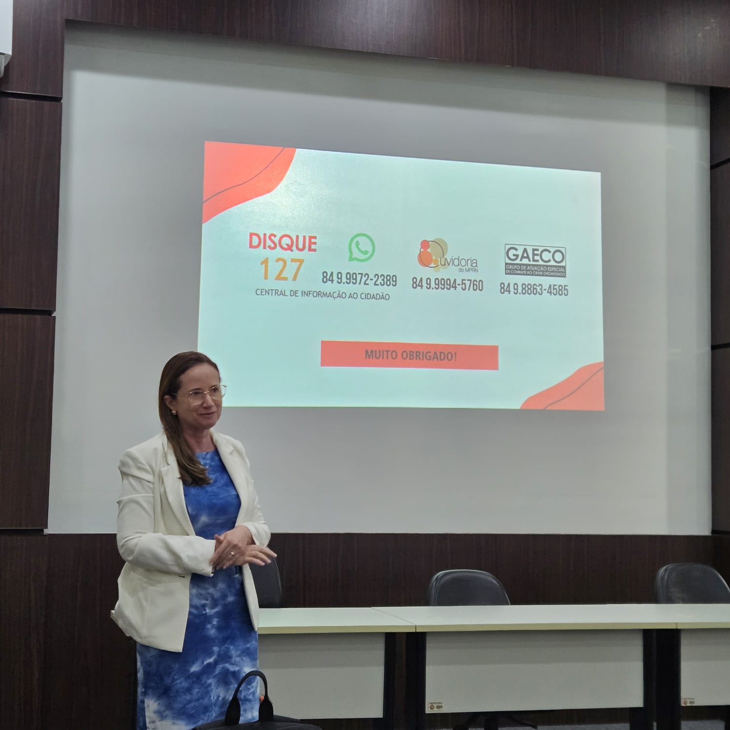promotora de justiça em pé em auditorio